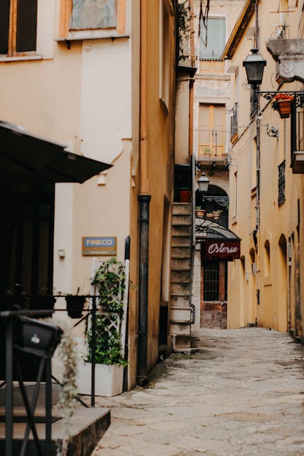 Mittelalterliche Kopfsteinpflasterstraße mit Außenosteria in Gerace an einem sonnigen Tag