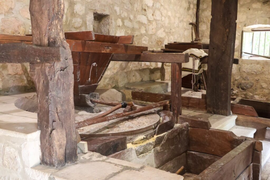 Historic wooden olive press and stone walls inside a Calabrian mill