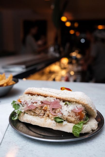 Panino garni de salade et viande, servi au comptoir calabrais