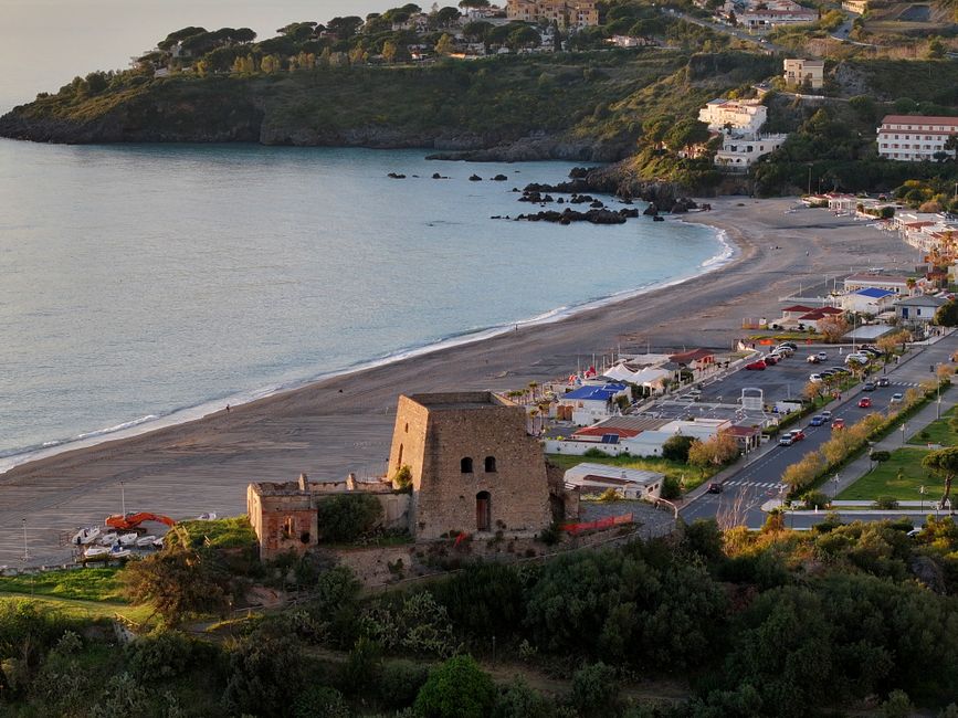 Zonsondergang aan de Calabrese kust met toeristen die genieten van straateten tijdens een festival