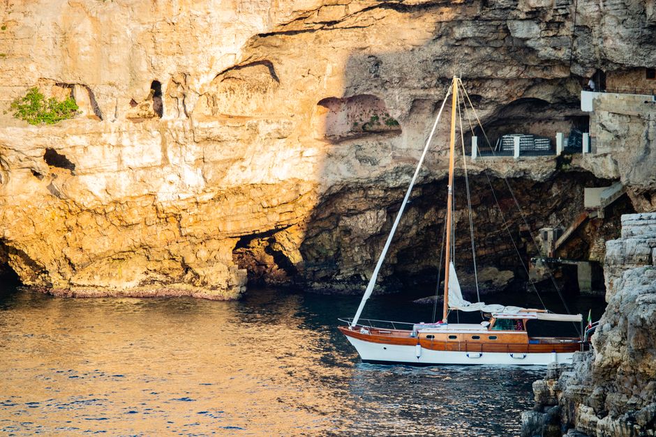 Voilier ancré près d'une falaise calcaire et grotte sur la côte calabraise