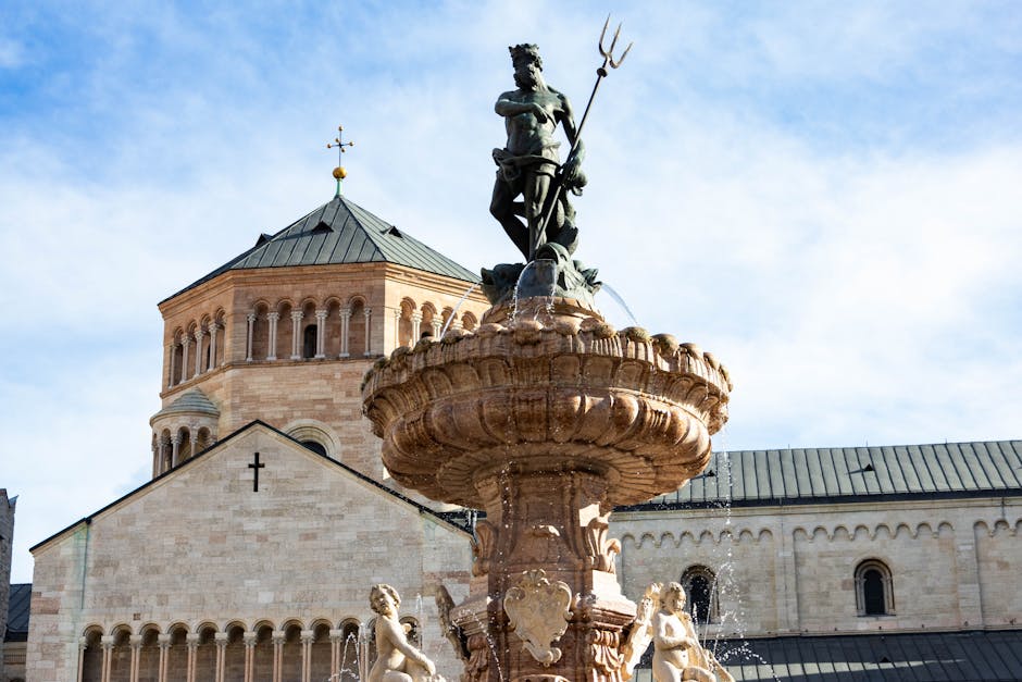 Fontaine du Neptune devant le Dôme de Trente sous ciel bleu