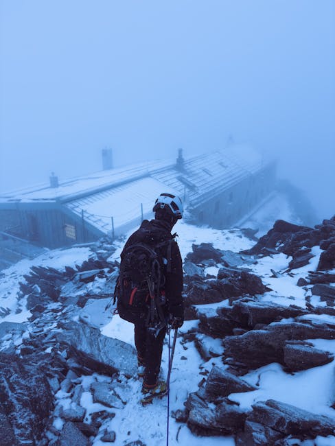 Alpiniste en cordée descendant vers un refuge enneigé dans le brouillard