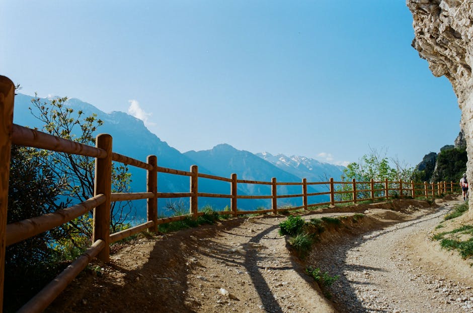 Sentier bordé de rambarde en bois, panorama montagnard près de Trente
