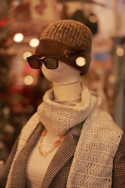 Mannequin en vitrine portant bonnet, écharpe et lunettes dans une boutique de Trente