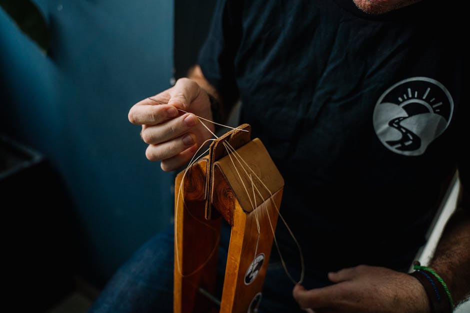 Hand eines Lederhandwerkers beim Nähen einer Ledertasche
