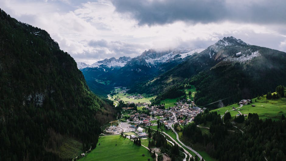 Vue aérienne d'un village alpin niché dans les vallées verdoyantes des Dolomites
