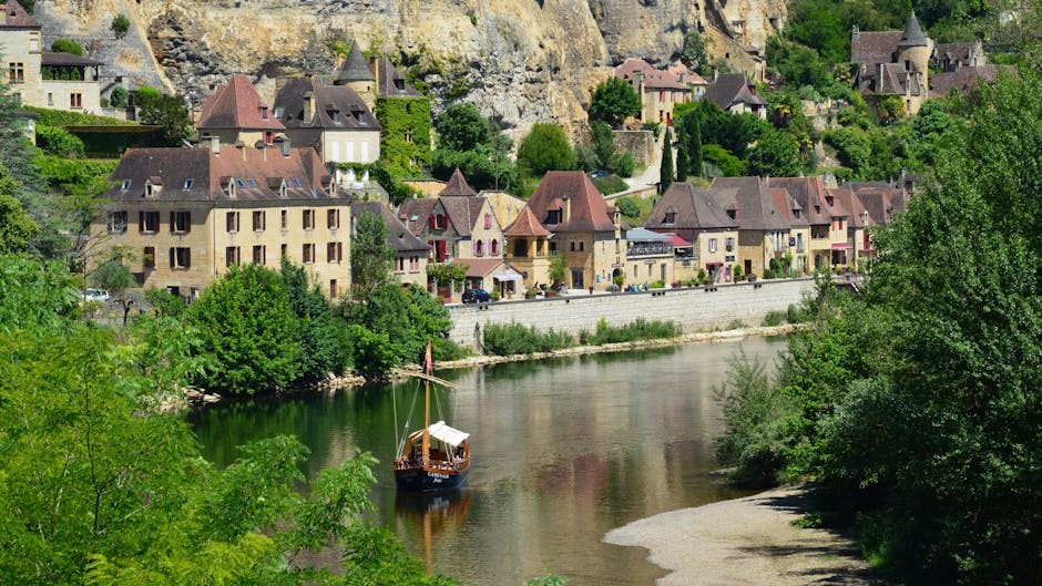 Reihen historischer Häuser am Fluss, kleines Boot treibt ruhig