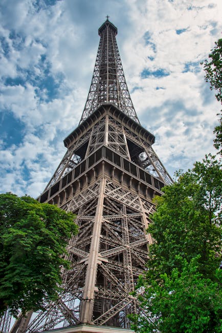 Angle bas de la tour Eiffel encadrée par des arbres à Paris