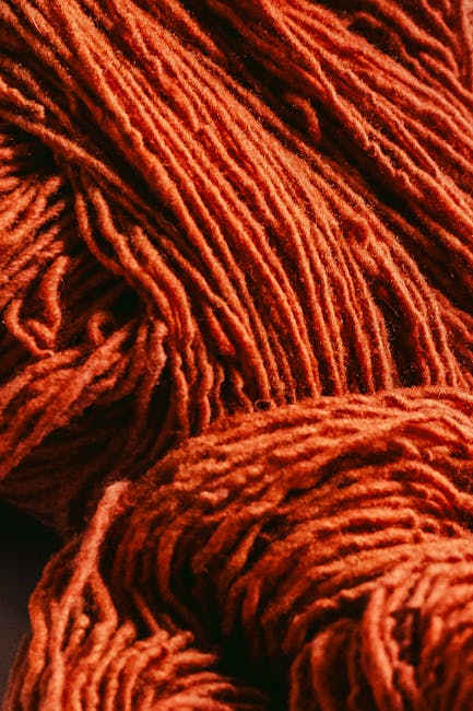 Rote Wollknäuel und Garnstränge bereit in Trienter Textilatelier.