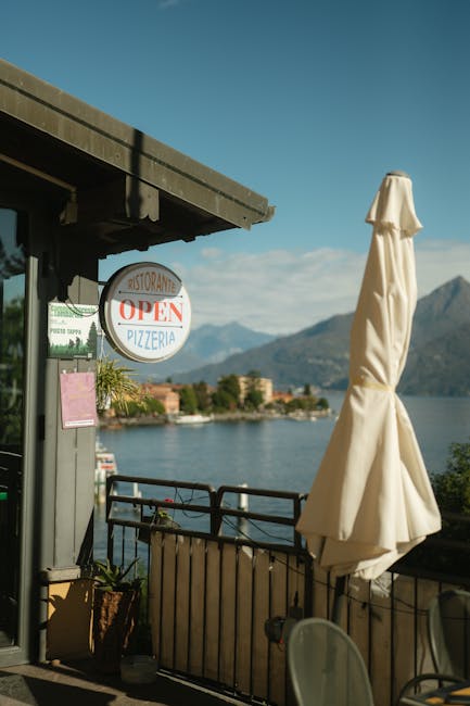 Terrasse avec enseigne OPEN PIZZERIA face au lac près de Trente.
