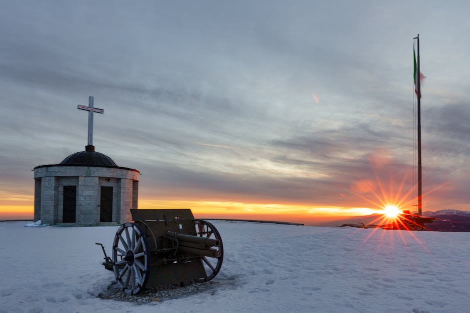 Chapelle ronde, vieux canon et drapeau sur la neige près de Trente
