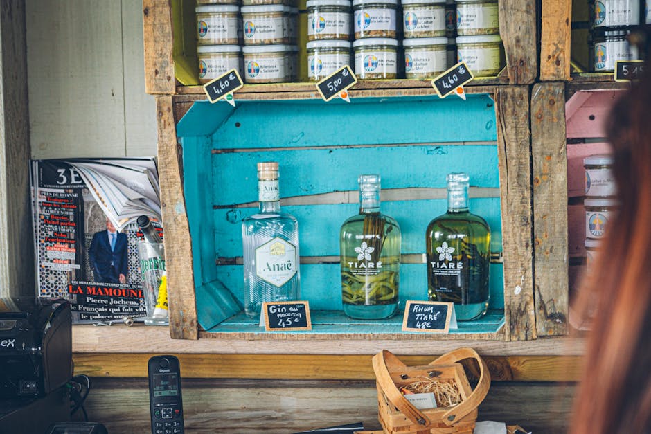Bouteilles de gin et rhum sur étagère en bois turquoise, étiquettes de prix à Trente