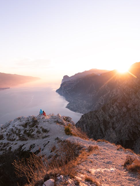 Deux randonneurs admirant le coucher de soleil sur le lac près de Trente