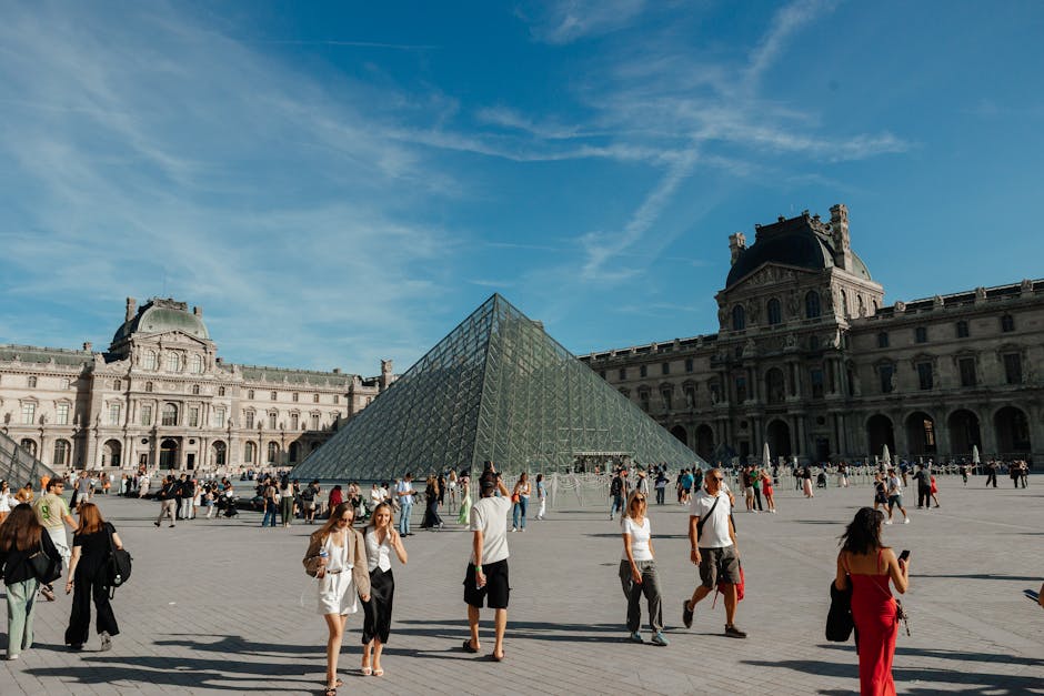Cour du Louvre avec pyramide de verre et visiteurs nombreux à Paris