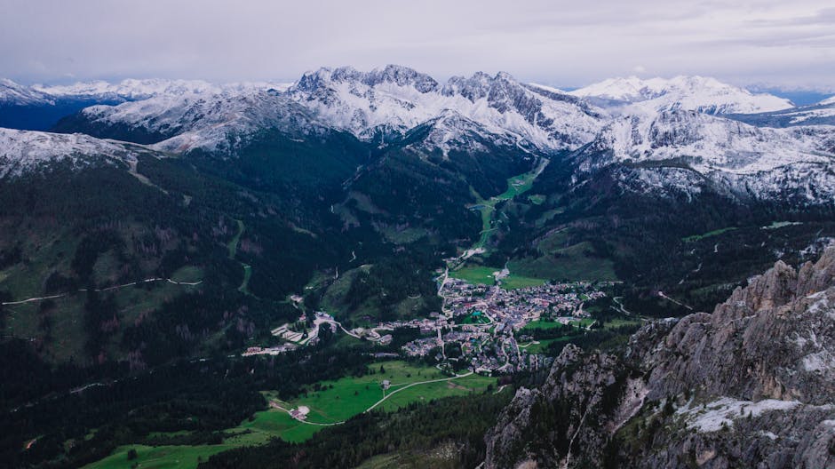 Panorama depuis un sommet des Dolomites sur vallées, villages et crêtes enneigées