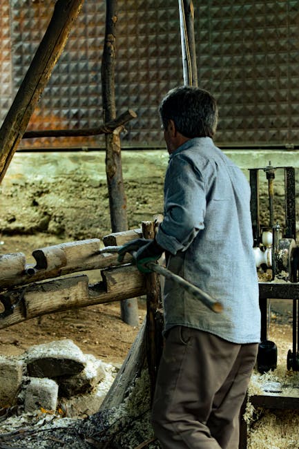 Handwerker dreht Holzstamm an traditioneller Drehbank in Trient.