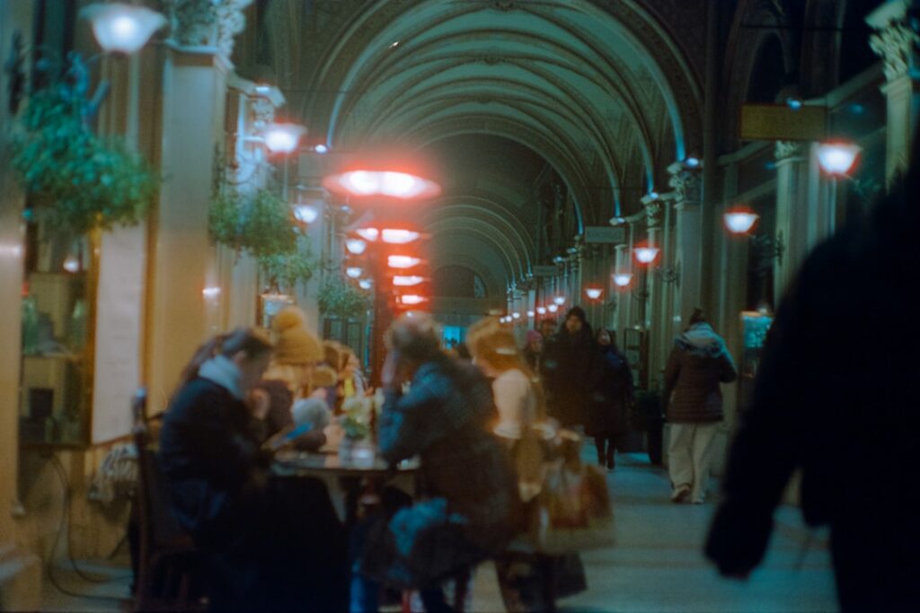 Evening street in Trento with lights and people dining