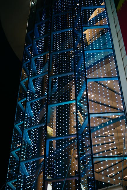 Façade vitrée avec structure et petites LED bleues scintillant la nuit.