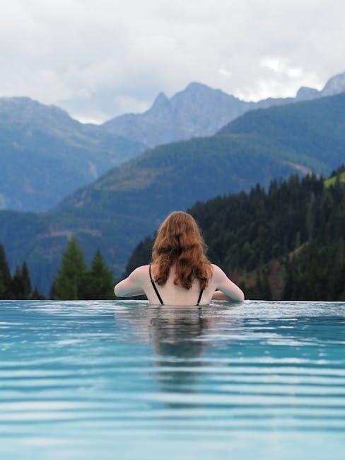 Femme de dos dans piscine à débordement face aux montagnes près de Trente