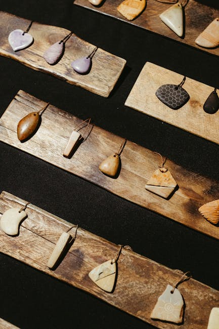 Pendentifs artisanaux disposés sur lattes de bois, souvenirs de Trente