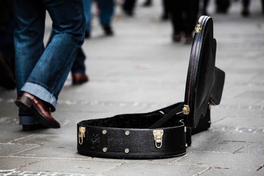 Étui de guitare ouvert sur le pavé dans les rues de Trente