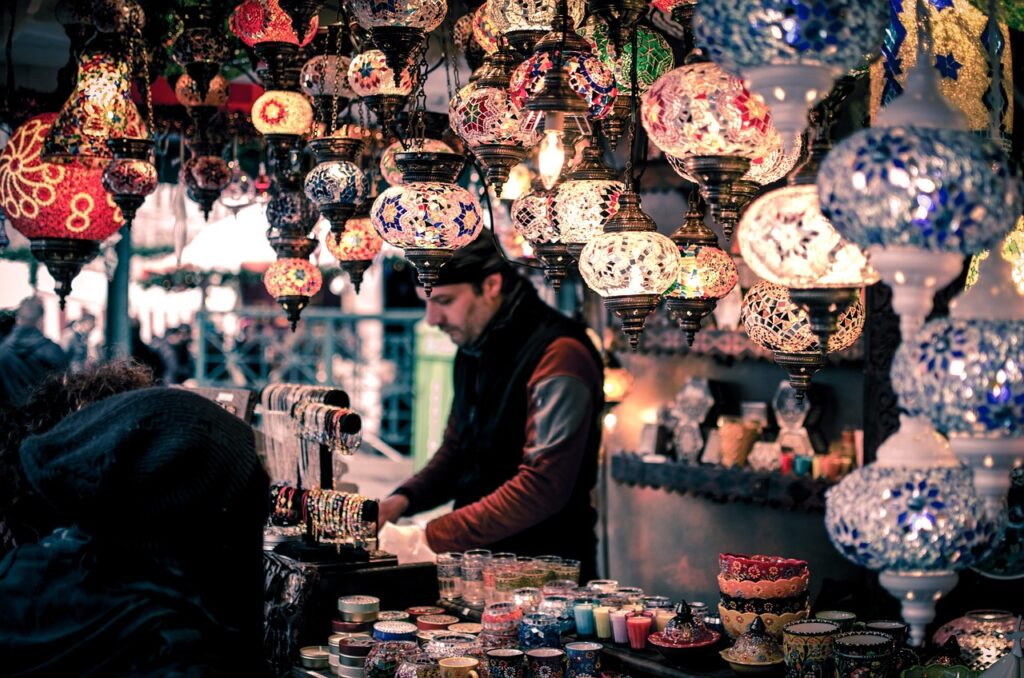 Étal de lanternes colorées et objets artisanaux animé dans un marché de Trente
