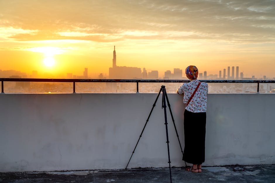 Fotografo urbano con treppiede sul tetto all'alba