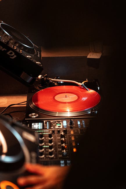 Gramofon z czerwonym winylem na konsolecie DJ-a w Trento