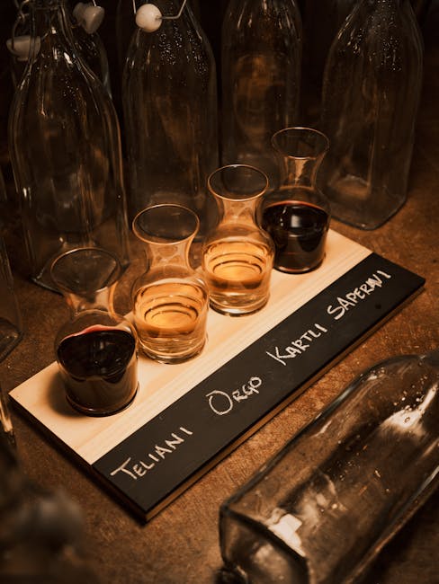 Four wine tasting carafes on wooden board in Trento cellar