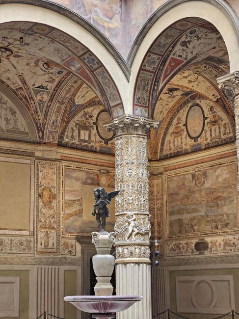 Colonne sculptée et fontaine avec putto sous voûtes peintes à Trente