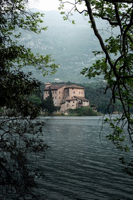 Château sur le lac de Toblino encadré par branchages, près de Trente