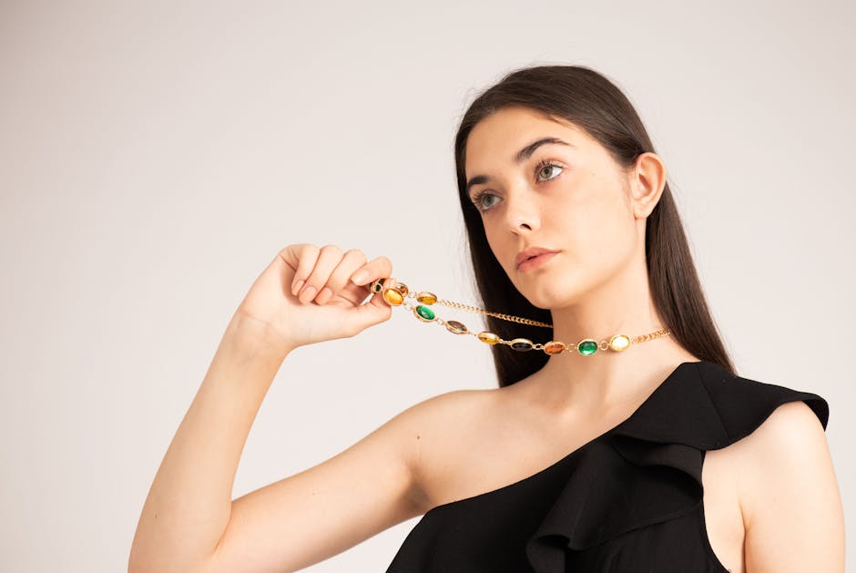Model toont fijne gouden ketting met groene en gele stenen