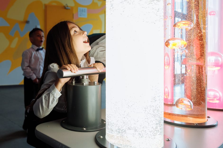 Enfant saisissant une manette devant colonnes lumineuses au MUSE de Trente