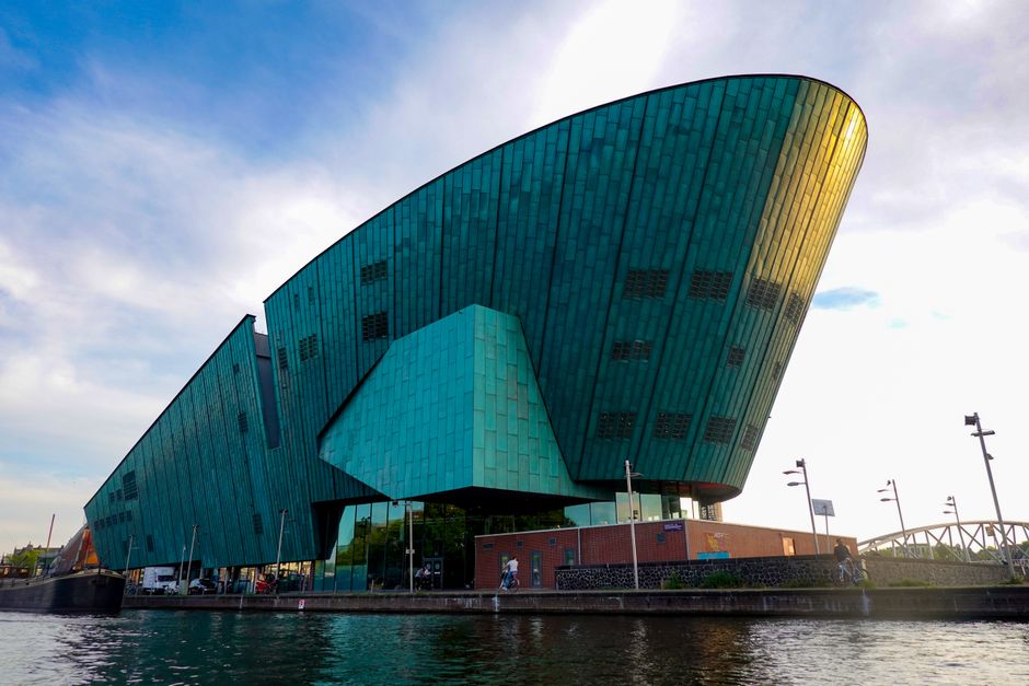 Bâtiment contemporain en cuivre vert au bord d'un canal
