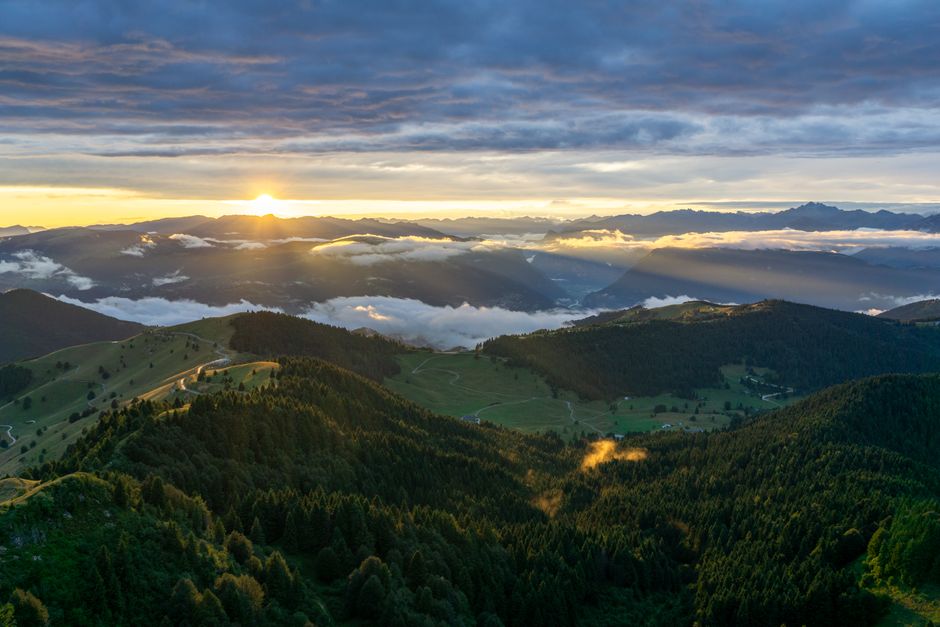 Lever du soleil sur collines et forêts autour de Trente, brumes basses