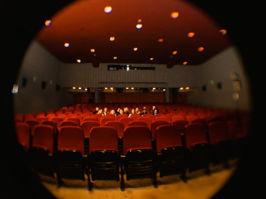 Small cinema auditorium in Trento with red seats and few audience members