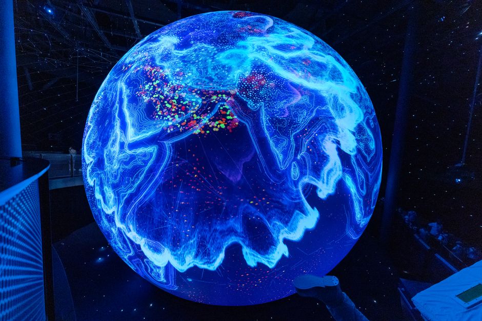 Globe lumineux bleu interactif exposé au musée MUSE de Trente