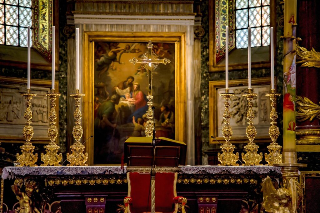 Gouden altaarkandelaars en centraal kruis voor schilderij in een kerk in Trento