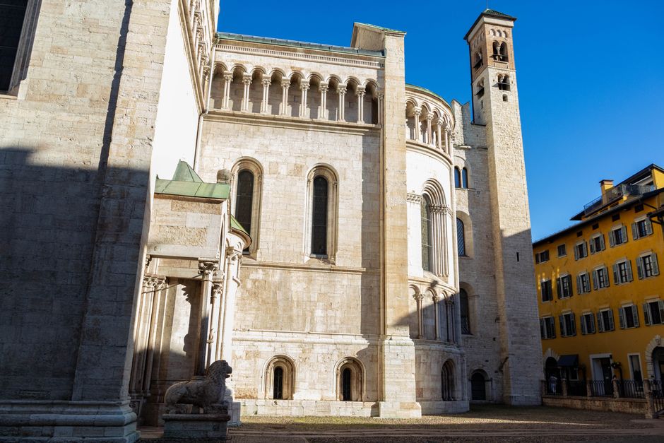 Historische kerkgevels in Trento en wandelende toeristen bij schemering