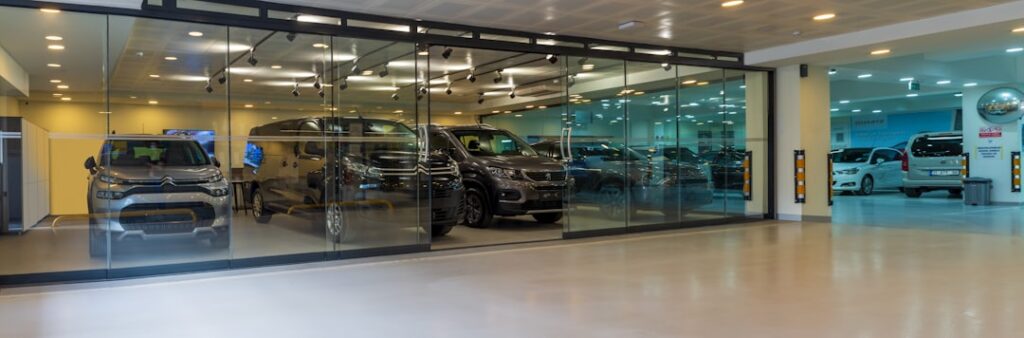 Glazen autoverkoopruimte met meerdere auto's zichtbaar in showroom