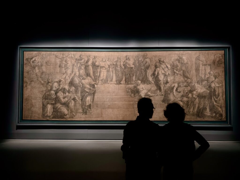 Zwei Silhouetten betrachten ein großes gezeichnetes Wandbild im Museum von Bari