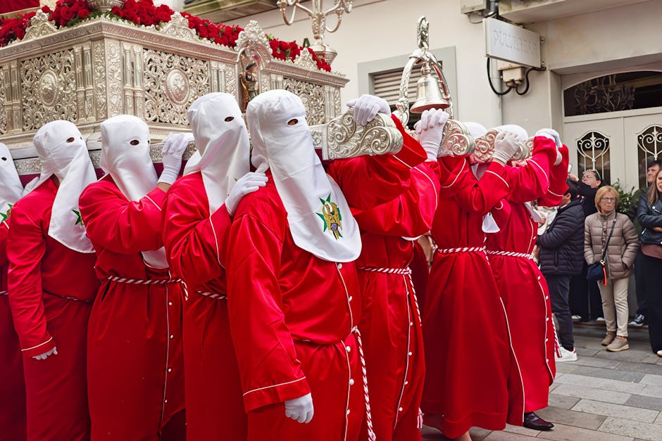 Participants en robes rouges et cagoules blanches portant une châsse argentée dans Bari