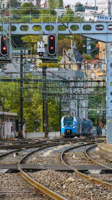 Train bleu s'approchant sur des rails et caténaires près de Bari