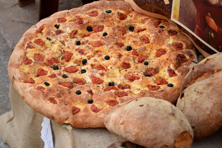 Large round focaccia topped with cherry tomatoes and black olives at Bari market