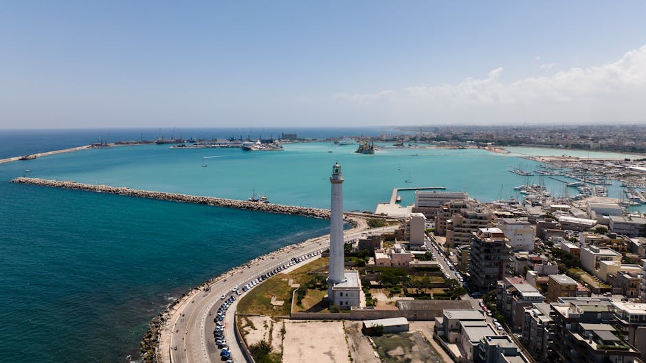 Vogelperspektive des Hafens von Bari mit weißem Leuchtturm und türkisfarbigem Meer