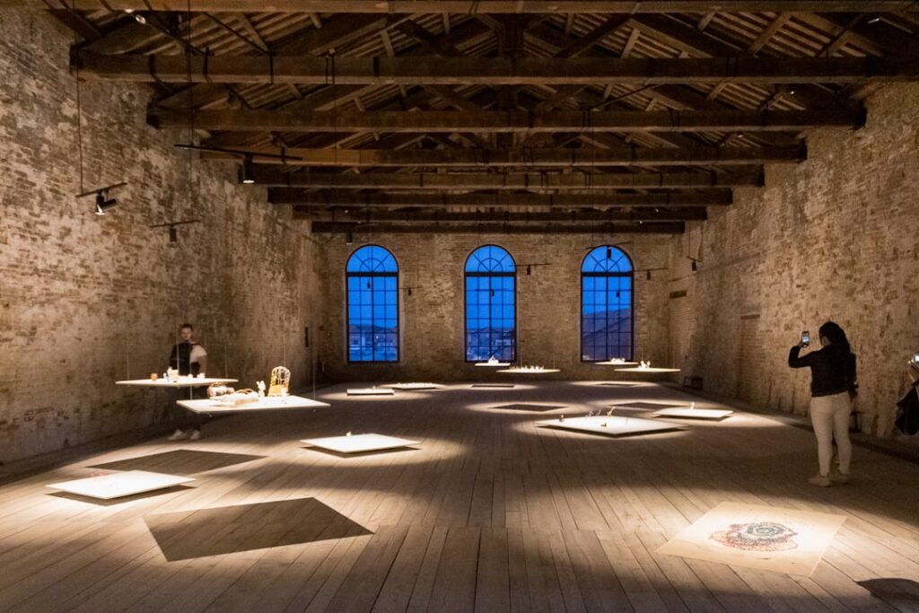 Ampia sala espositiva a Bari con pavimento in legno e installazioni sospese