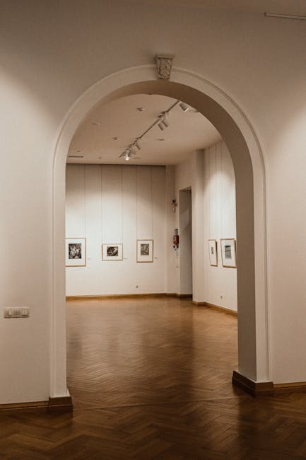 Arco che incornicia una sala espositiva a Bari con opere appese
