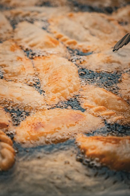 Golden panzerotti frying in bubbling oil at a Bari street stall