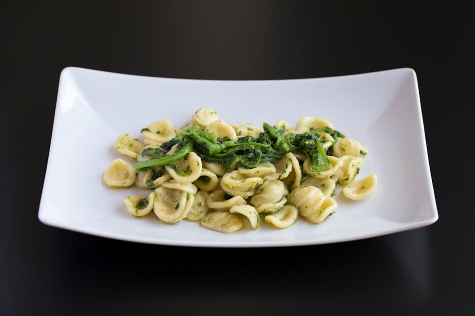 White plate of orecchiette pasta with greens, typical of Bari.